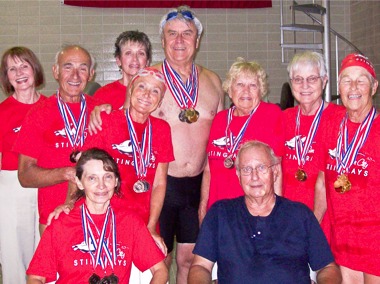 Stingrays’ Swim Club members at the Park Ridge Swim Meet are (first row, sitting from left) Ginny McCann and Coach Jack Bolger; (second row, standing from left) Nick Koplos, Joanie Koplos, Dave Strang, Joan Souchek, Phyllis Nordlof, and Caryl Fabian; (back row, from left-cheerleading for their team) Inge Sedey and Pat Hutton. Missing from the picture are swimmer Art Fitzgerald, and cheerleaders Jack McCann and Paul Souchek.