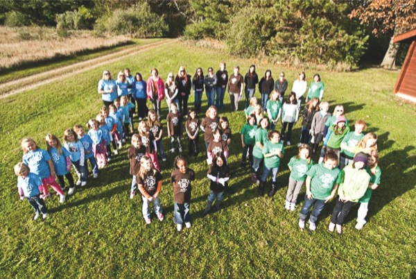 To honor the Girl Scouts 100-year anniversary, Corron Elementary School Brownie troop 4622, along with other local troops, headed to Camp Tomo Chi-Chi Knolls of the Kane County Forest Preserve in Gilberts. There they formed the number 100 for this photo. (Photo provided)