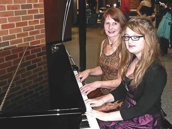 Sedey with her granddaughter playing one of the grands before last year's concert. (Photo provided)