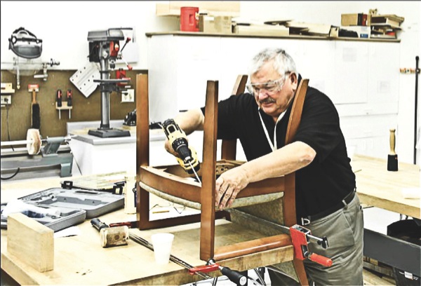 Tony Troy tightens the loose legs on a chair from the Arcadia condominiums. (Photo provided)