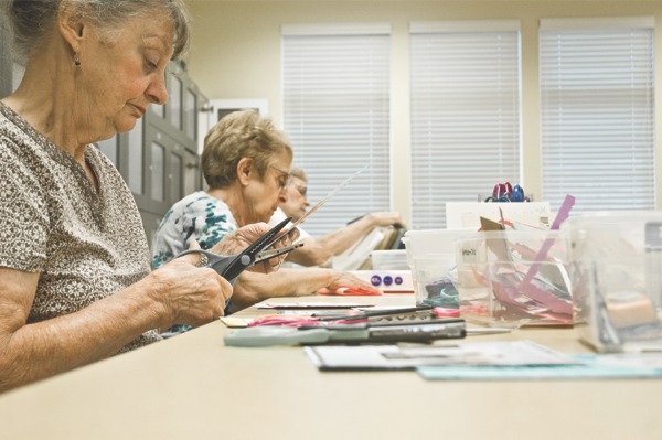 Members of Edgewater’s Kardz R Us club assemble new cards from those the club received from donors. Finished cards are sold in Creekside Lodge for $1, and all profits go to the Community Crisis Center in Elgin. (Photo by Mason Souza/Sun Day)