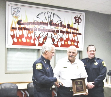 Former Huntley Fire Chief Jim Saletta (center) is presented with a plaque by Huntley Chief of Police John Perkins (left) and Deputy Chief Todd Fulton (right) during a Nov. 2 open house ceremony for Saletta’s retirement. (Photo by Mason Souza/Sun Day)