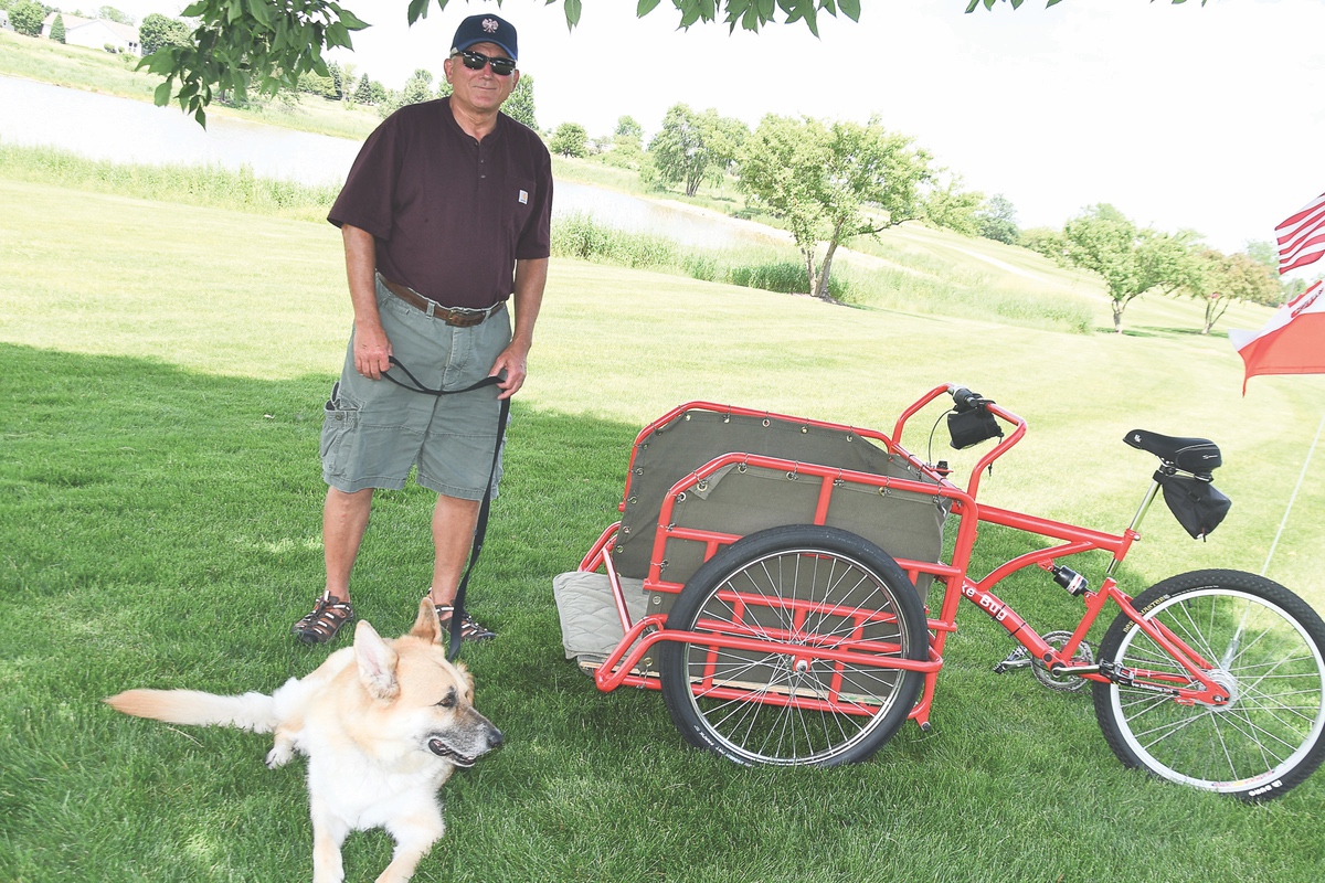 Due to issues with his hind legs, PJ, a German Shepherd, “rides” around Sun City in special bicycle equipped with a cart. According to his owner Rich Koziol, PJ loves it! (Photo by Christine Such/Sun Day)