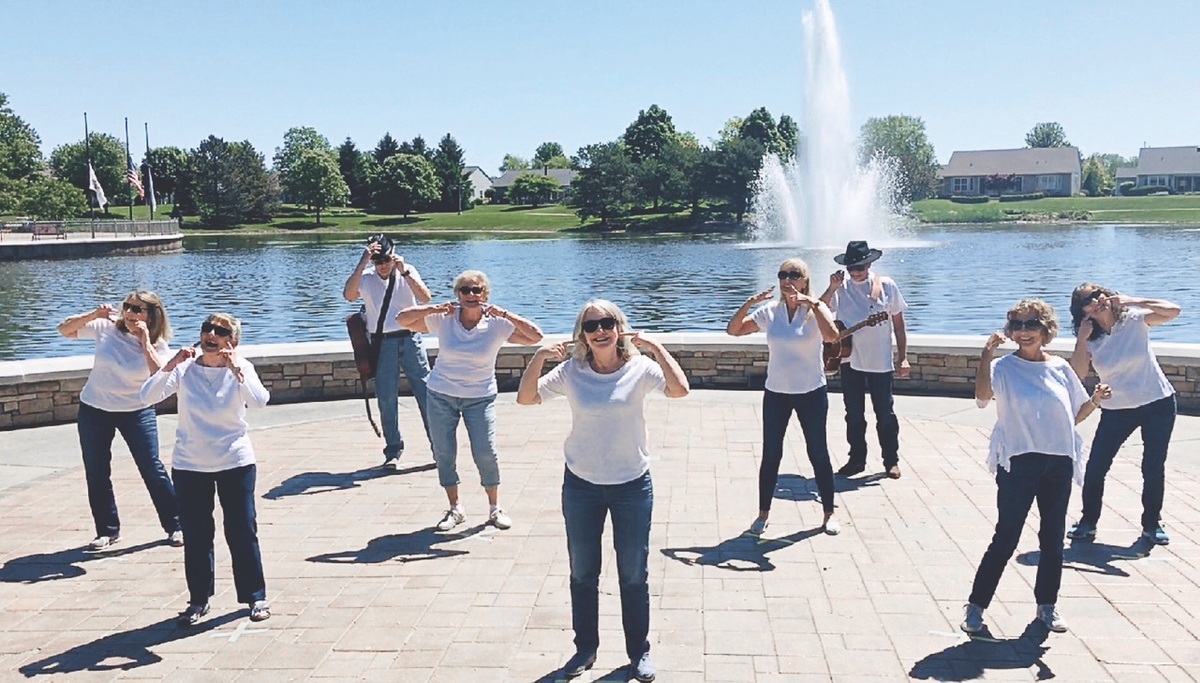 While maintaining social distancing, residents took part in a community dance-off. The group here met at the pavilion and stood on spaced Xs. (Photo by Christine Such/Sun Day)