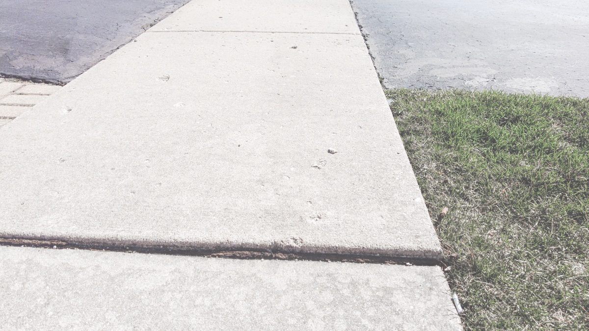 Sidewalk squares like this one occasionally pop up as a result of varying factors and present sometimes unseen dangers for pedestrians. The village, however, has a program in place to repair these uneven walking surfaces. (Photo by Tony Pratt/Sun Day)