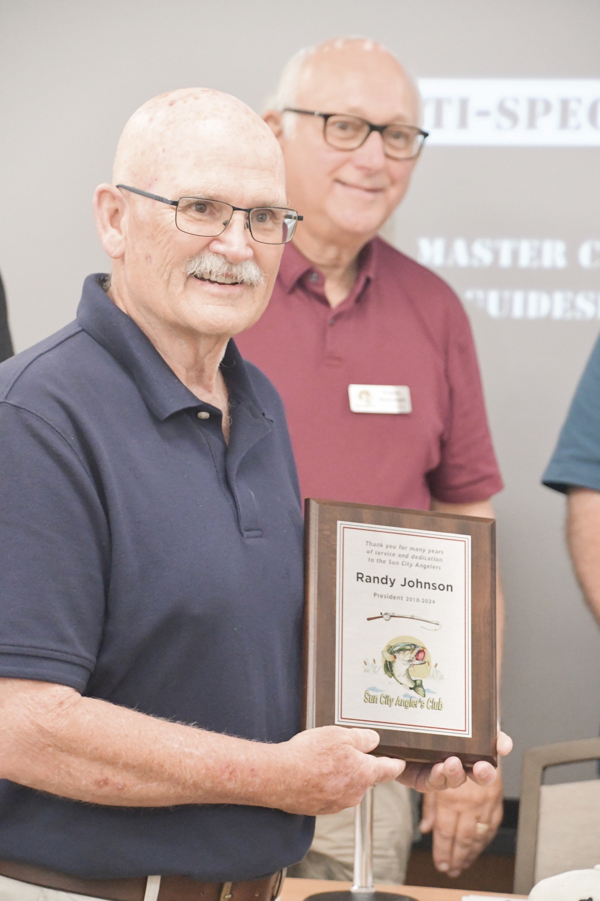 Outgoing Angler’s Club President Randy Johnson receives a plaque expressing the club’s thanks for his service. (Photo by Christine Such/My Sun Day News)