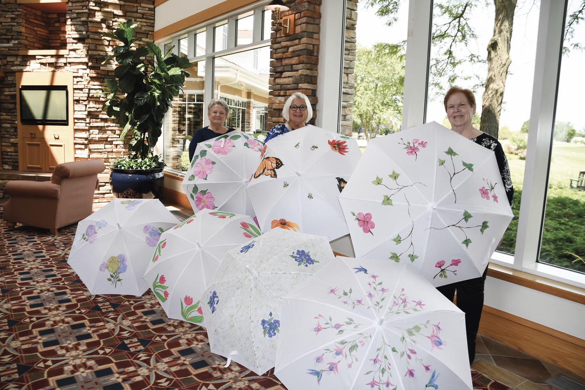 (L to R) Pencil and Palette Club members Barbara Schramm, Linda Wadman, and Carolyn Gordon with hand-painted umbrellas to be raffled on September 21st. (Photo by Christine Such/My Sun Day News)