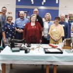 Sun City Volunteers with Heineman Middle School teacher Todd Ary (second from left) display items from their childhoods. (Photo by Christine Such/My Sun Day News)