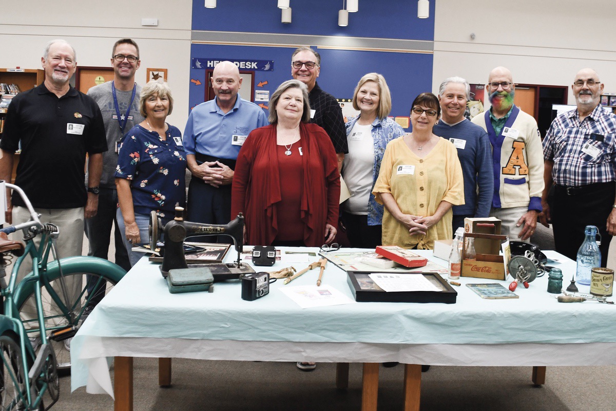 Sun City Volunteers with Heineman Middle School teacher Todd Ary (second from left) display items from their childhoods. (Photo by Christine Such/My Sun Day News)