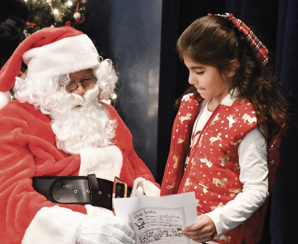 Sun City granddaughter Victoria Jimenez shares her Christmas list with Santa at the recent Grandma, Grandpa & Me breakfast with Santa. (Photo by Christine Such/My Sun Day News)