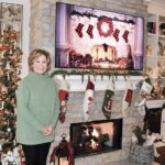 June Vedder poses beside one of her Christmas trees and her fireplace adorned with hung stockings. (Photos by Christine Such/My Sun Day News)