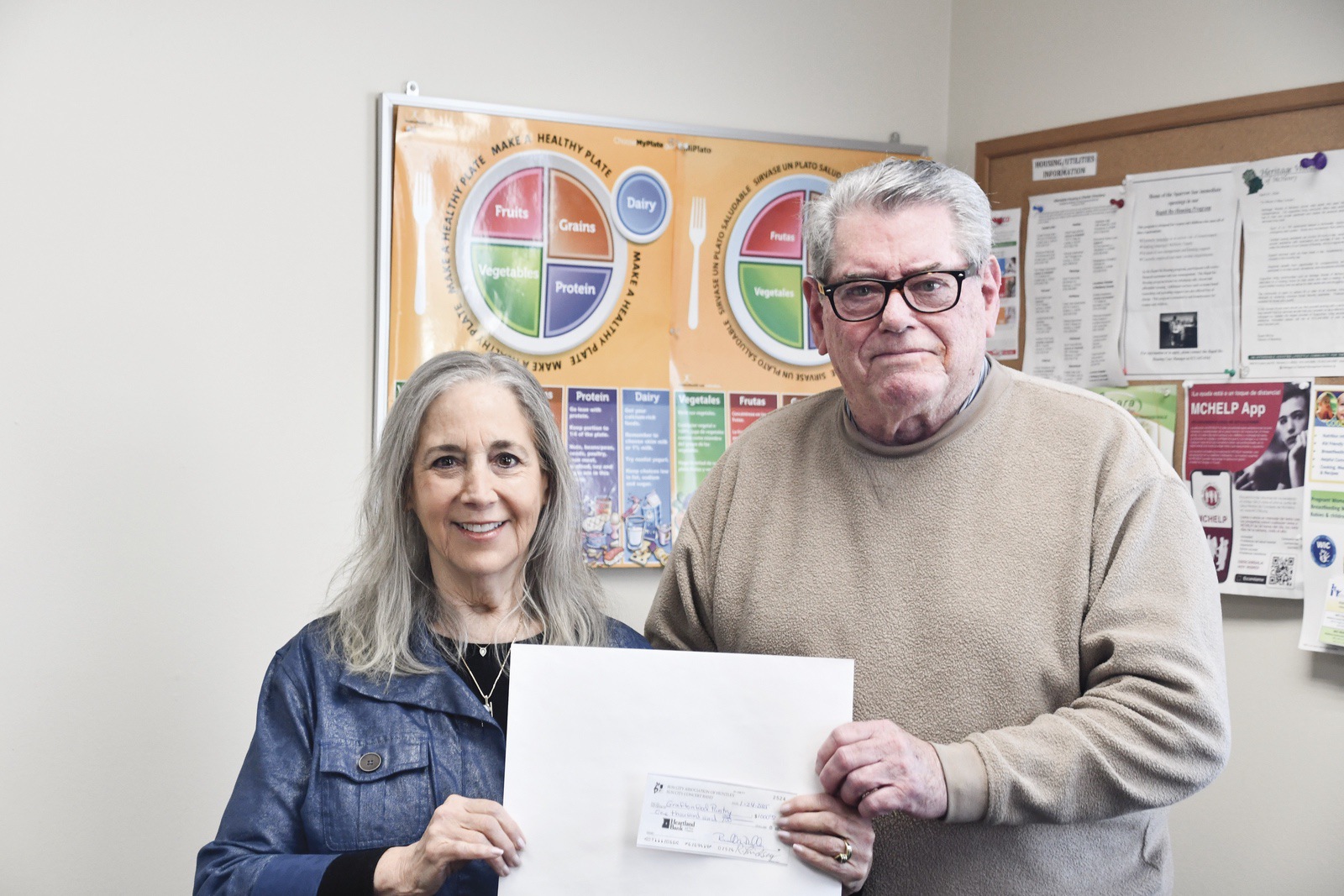 Rob Lindsay hands a generous donation from Sun CIty Concert Band to Harriet Ford for the Grafton Food Pantry. (Photo by Christine Such/My Sun Day News)