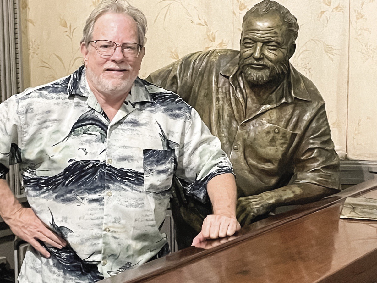 Traveler Bill Dollar poses next to Hemingway's statue.